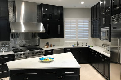 Transitional eat-in kitchen photo in Dallas with raised-panel cabinets, black cabinets and two islands