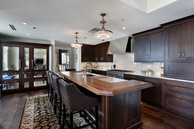 Transitional kitchen photo in Atlanta with dark wood cabinets, wood countertops, white backsplash and stone slab backsplash
