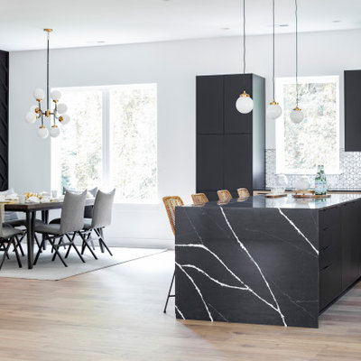 Example of a trendy kitchen design in Charlotte with flat-panel cabinets, black cabinets, quartz countertops, white backsplash, an island and black countertops