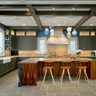 Foto de cocina en U con fregadero sobremueble, armarios con paneles lisos, puertas de armario marrones, salpicadero multicolor, electrodomésticos de acero inoxidable, una isla y suelo gris