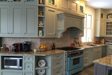 Foto på ett stort vintage kök, med en undermonterad diskho, luckor med profilerade fronter, gröna skåp, granitbänkskiva, beige stänkskydd, stänkskydd i stenkakel, rostfria vitvaror, klinkergolv i porslin och en köksö