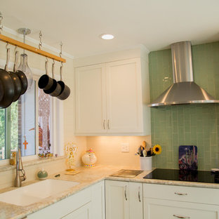 This is an example of a small transitional l-shaped open plan kitchen in Denver with an integrated sink, recessed-panel cabinets, white cabinets, laminate benchtops, green splashback, glass tile splashback, stainless steel appliances, linoleum floors and with island.