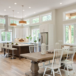 Design ideas for an expansive transitional u-shaped eat-in kitchen in Atlanta with a farmhouse sink, shaker cabinets, white cabinets, quartz benchtops, beige splashback, glass tile splashback, stainless steel appliances, porcelain floors, with island, beige floor and white benchtop.
