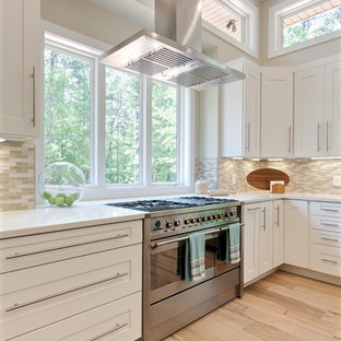 This is an example of an expansive contemporary u-shaped eat-in kitchen in Atlanta with a farmhouse sink, shaker cabinets, white cabinets, quartz benchtops, beige splashback, glass tile splashback, stainless steel appliances, porcelain floors, with island, beige floor and white benchtop.