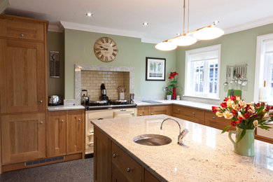 Klassische Küche mit Schrankfronten im Shaker-Stil, hellbraunen Holzschränken und Granit-Arbeitsplatte in Cambridgeshire