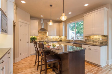 Example of a transitional eat-in kitchen design in Portland with recessed-panel cabinets and an island