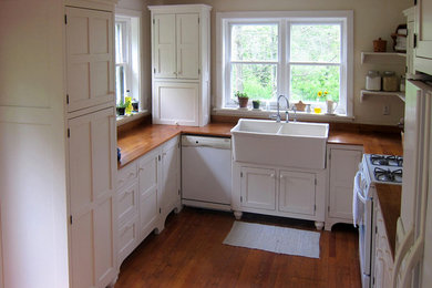 Mid-sized cottage u-shaped medium tone wood floor kitchen photo in Philadelphia with a farmhouse sink, shaker cabinets, white cabinets and wood countertops