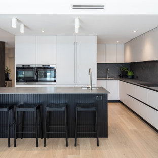 Contemporary kitchen in Perth with grey cabinets, tile benchtops, grey splashback, porcelain splashback, light hardwood floors, with island and grey benchtop.