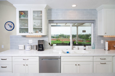 Example of a mid-sized trendy u-shaped vinyl floor and gray floor enclosed kitchen design in San Diego with a double-bowl sink, shaker cabinets, white cabinets, quartzite countertops, blue backsplash, subway tile backsplash, stainless steel appliances, an island and white countertops