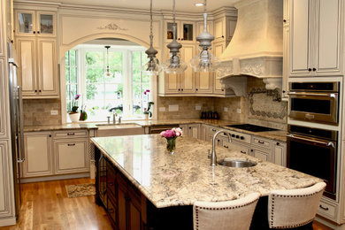 Example of a large classic u-shaped light wood floor and beige floor enclosed kitchen design in Raleigh with a farmhouse sink, beaded inset cabinets, white cabinets, granite countertops, beige backsplash, porcelain backsplash, stainless steel appliances, an island and multicolored countertops