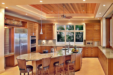 Inspiration for a mid-sized tropical u-shaped travertine floor open concept kitchen remodel in Hawaii with an undermount sink, louvered cabinets, medium tone wood cabinets, marble countertops, beige backsplash, stone slab backsplash, stainless steel appliances and an island