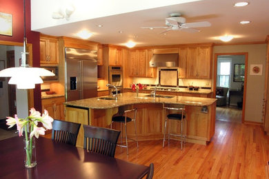 На фото: угловая кухня среднего размера в стиле фьюжн с обеденным столом, фасадами с утопленной филенкой, гранитной столешницей и островом