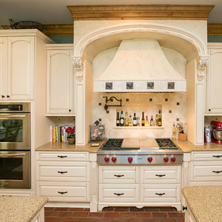 Traditional kitchen inspiration - Example of a classic kitchen design in Dallas with raised-panel cabinets, beige cabinets, beige backsplash and stainless steel appliances