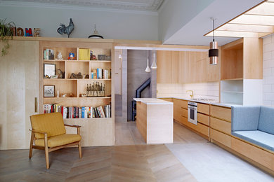 Ejemplo de cocina actual con armarios con paneles lisos, puertas de armario de madera oscura, salpicadero blanco y una isla