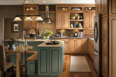 Eat-in kitchen - transitional l-shaped medium tone wood floor and brown floor eat-in kitchen idea in Boston with an undermount sink, raised-panel cabinets, medium tone wood cabinets, brown backsplash, stainless steel appliances, an island, quartzite countertops and ceramic backsplash