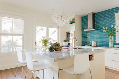 Inspiration for a mid-sized contemporary l-shaped medium tone wood floor and brown floor eat-in kitchen remodel in Boston with an undermount sink, flat-panel cabinets, white cabinets, marble countertops, blue backsplash, subway tile backsplash, stainless steel appliances and an island