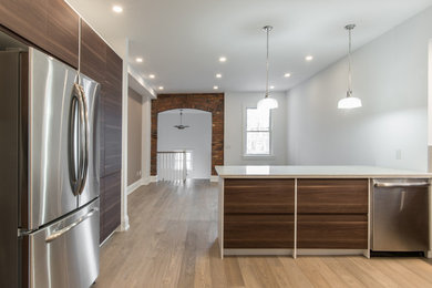 Inspiration for a mid-sized transitional u-shaped light wood floor open concept kitchen remodel in Toronto with an undermount sink, flat-panel cabinets, medium tone wood cabinets, quartz countertops, gray backsplash, ceramic backsplash, stainless steel appliances and a peninsula