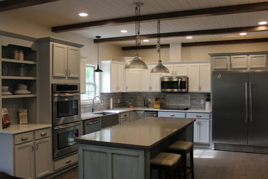 Mid-sized country u-shaped medium tone wood floor and gray floor eat-in kitchen photo in Other with a farmhouse sink, shaker cabinets, gray cabinets, quartz countertops, gray backsplash, ceramic backsplash, stainless steel appliances, an island and gray countertops