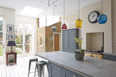 Inspiration for an industrial grey and cream kitchen in London with recessed-panel cabinets, blue cabinets, concrete worktops, metro tiled splashback and coloured appliances.