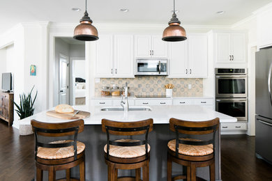 Example of a large transitional dark wood floor kitchen design in Other with a drop-in sink, white cabinets, quartz countertops, white backsplash, cement tile backsplash, stainless steel appliances and an island