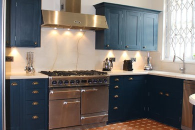 Inspiration for a medium sized classic u-shaped enclosed kitchen in London with a built-in sink, shaker cabinets, blue cabinets, marble worktops, white splashback, stone slab splashback, stainless steel appliances, ceramic flooring and no island.