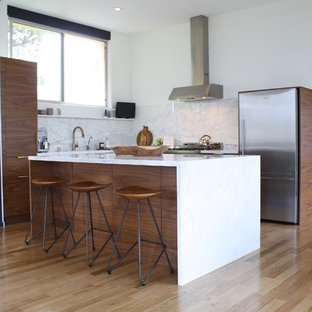 Contemporary open concept kitchen pictures - Example of a trendy l-shaped light wood floor open concept kitchen design in Los Angeles with flat-panel cabinets, medium tone wood cabinets, white backsplash, stainless steel appliances, an island, marble countertops, a single-bowl sink and marble backsplash