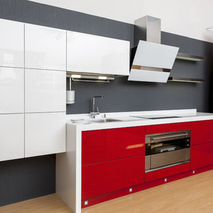 Inspiration for a mid-sized modern single-wall eat-in kitchen in Las Vegas with flat-panel cabinets, white cabinets, laminate benchtops, white splashback, plywood floors, with island, beige floor and white benchtop.