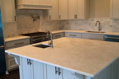 Photo of a large traditional kitchen in New Orleans with recessed-panel cabinets, white cabinets, marble worktops, stone tiled splashback, stainless steel appliances, dark hardwood flooring and an island.