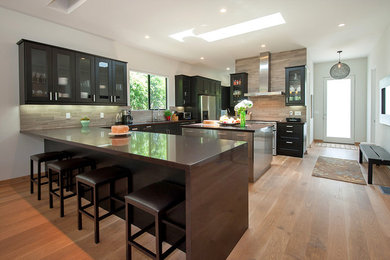 Example of a minimalist u-shaped open concept kitchen design in Los Angeles with an island