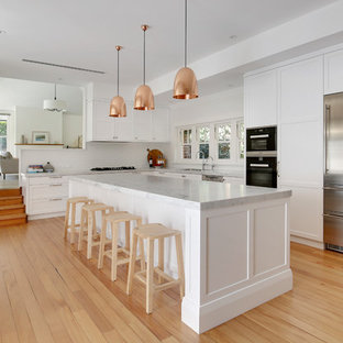 Foto di una grande cucina classica con lavello a doppia vasca, ante in stile shaker, ante bianche, top in marmo, paraspruzzi bianco, paraspruzzi con piastrelle in ceramica, elettrodomestici in acciaio inossidabile, parquet chiaro e pavimento giallo