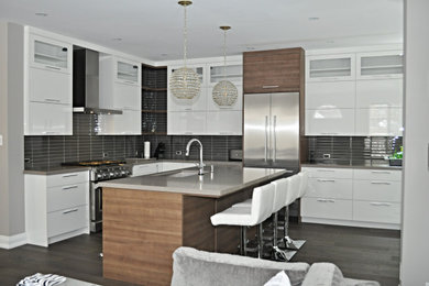 Eat-in kitchen - large modern l-shaped medium tone wood floor and brown floor eat-in kitchen idea in Toronto with an undermount sink, flat-panel cabinets, white cabinets, quartz countertops, gray backsplash, glass tile backsplash, stainless steel appliances, an island and gray countertops