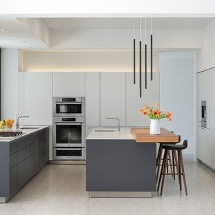 Idées déco pour une cuisine grise et blanche sud-ouest américain en U de taille moyenne avec un placard à porte plane, des portes de placard blanches, un plan de travail en quartz modifié, un sol en carrelage de porcelaine, un îlot central, une crédence blanche, un sol blanc, une crédence en carreau de porcelaine, un évier encastré, un électroménager encastrable et un plan de travail blanc.