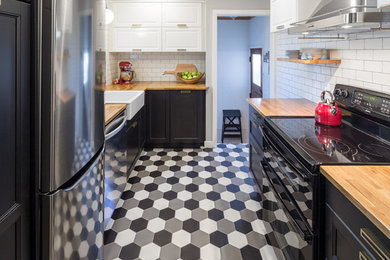Inspiration for a small transitional galley ceramic tile enclosed kitchen remodel in Ottawa with a farmhouse sink, recessed-panel cabinets, wood countertops, white backsplash, subway tile backsplash, stainless steel appliances and no island