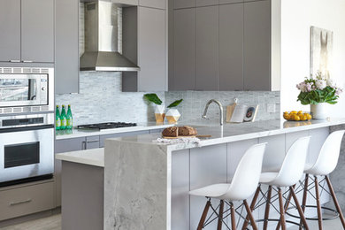 Medium sized contemporary u-shaped kitchen in Toronto with flat-panel cabinets, grey cabinets, granite worktops, grey splashback, stone tiled splashback, stainless steel appliances, porcelain flooring and a breakfast bar.