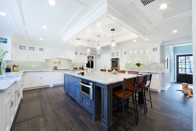 Example of a large transitional u-shaped open concept kitchen design with recessed-panel cabinets, white cabinets, marble countertops, green backsplash, glass tile backsplash, paneled appliances, an island and white countertops