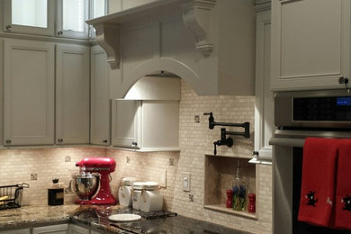 Example of a huge classic l-shaped travertine floor eat-in kitchen design in Other with an undermount sink, recessed-panel cabinets, white cabinets, laminate countertops, beige backsplash, stone tile backsplash, stainless steel appliances and an island