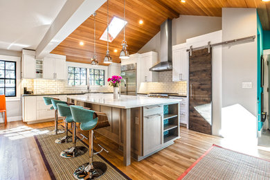Kitchen - transitional u-shaped kitchen idea in Seattle with shaker cabinets, white cabinets, white backsplash and an island
