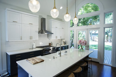 Inspiration for a mid-sized contemporary galley dark wood floor and brown floor eat-in kitchen remodel in Seattle with a farmhouse sink, shaker cabinets, blue cabinets, solid surface countertops, white backsplash, subway tile backsplash, stainless steel appliances, an island and white countertops