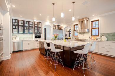 Inspiration for a traditional l-shaped kitchen in Denver with shaker cabinets, white cabinets, green splashback, stainless steel appliances, medium hardwood flooring and an island.