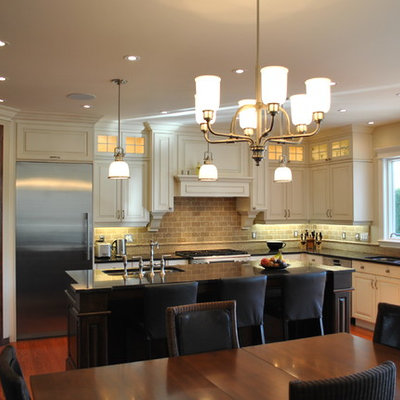 Elegant eat-in kitchen photo in Ottawa with raised-panel cabinets, white cabinets, stainless steel appliances and travertine backsplash