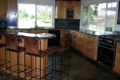 Example of a kitchen design in San Francisco with light wood cabinets and black appliances
