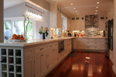 Inspiration for a mid-sized contemporary u-shaped medium tone wood floor and brown floor eat-in kitchen remodel in DC Metro with an undermount sink, shaker cabinets, white cabinets, marble countertops, gray backsplash, matchstick tile backsplash, stainless steel appliances and a peninsula