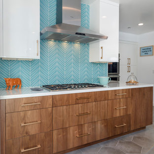 Geschlossene, Große Retro Küche in U-Form mit Unterbauwaschbecken, flächenbündigen Schrankfronten, hellbraunen Holzschränken, Quarzit-Arbeitsplatte, Küchenrückwand in Blau, Rückwand aus Glasfliesen, Küchengeräten aus Edelstahl, Zementfliesen, Kücheninsel und grauem Boden in Los Angeles