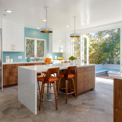 Large mid-century modern u-shaped cement tile floor and gray floor enclosed kitchen photo in Los Angeles with an undermount sink, flat-panel cabinets, medium tone wood cabinets, quartzite countertops, blue backsplash, glass tile backsplash, stainless steel appliances and an island