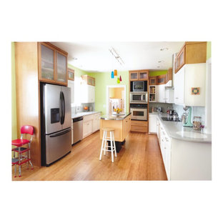 This is an example of a large contemporary u-shaped eat-in kitchen in Oklahoma City with an integrated sink, flat-panel cabinets, white cabinets, solid surface benchtops, glass tile splashback, stainless steel appliances, bamboo floors and with island.