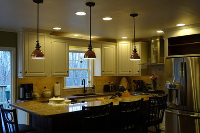 Example of a mid-sized classic u-shaped ceramic tile eat-in kitchen design in DC Metro with an undermount sink, raised-panel cabinets, white cabinets, granite countertops, beige backsplash, ceramic backsplash, stainless steel appliances and an island