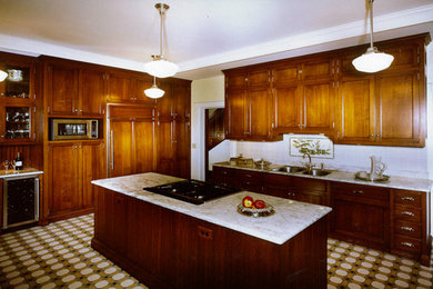 Example of a large l-shaped eat-in kitchen design in Cincinnati with a double-bowl sink, medium tone wood cabinets, marble countertops, white backsplash, ceramic backsplash and an island
