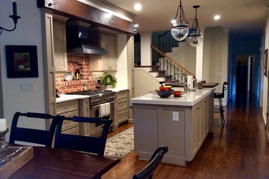 Example of a mid-sized transitional galley dark wood floor eat-in kitchen design in Raleigh with an undermount sink, shaker cabinets, beige cabinets, quartz countertops, red backsplash, brick backsplash, stainless steel appliances and an island