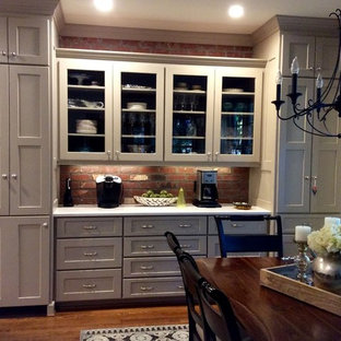Mid-sized transitional galley eat-in kitchen in Raleigh with an undermount sink, shaker cabinets, beige cabinets, quartz benchtops, red splashback, brick splashback, stainless steel appliances, dark hardwood floors and with island.