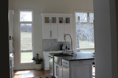 Ejemplo de cocina lineal contemporánea grande abierta con armarios estilo shaker, puertas de armario blancas, encimera de mármol, salpicadero blanco, salpicadero de azulejos de vidrio y una isla